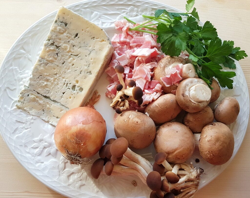 ingredients for gorgonzola, pancetta and mushroom pasta sauce on white plate