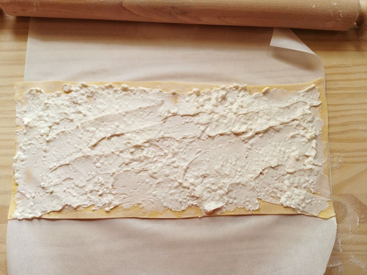 Sheet of fresh pasta covered in stracchino cheese.