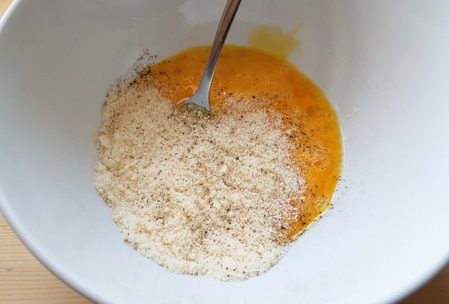 eggs, grated cheese and ground pepper in white bowl