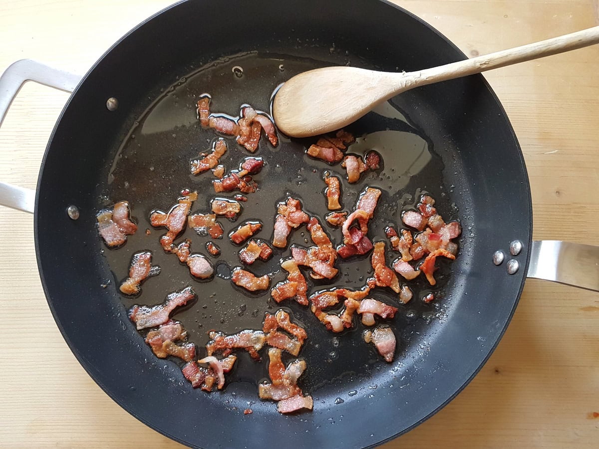 Ready cooked crispy guanciale pieces in skillet.