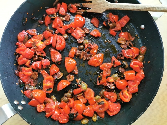 chopped tomatoes and olives in skillet with parsley and fennel seeds