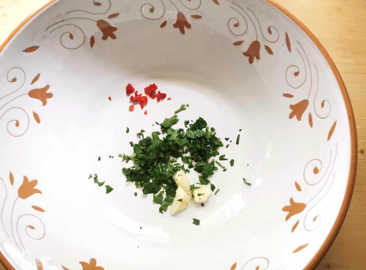 crushed garlic, chopped parsley and peperoncino in a large white bowl