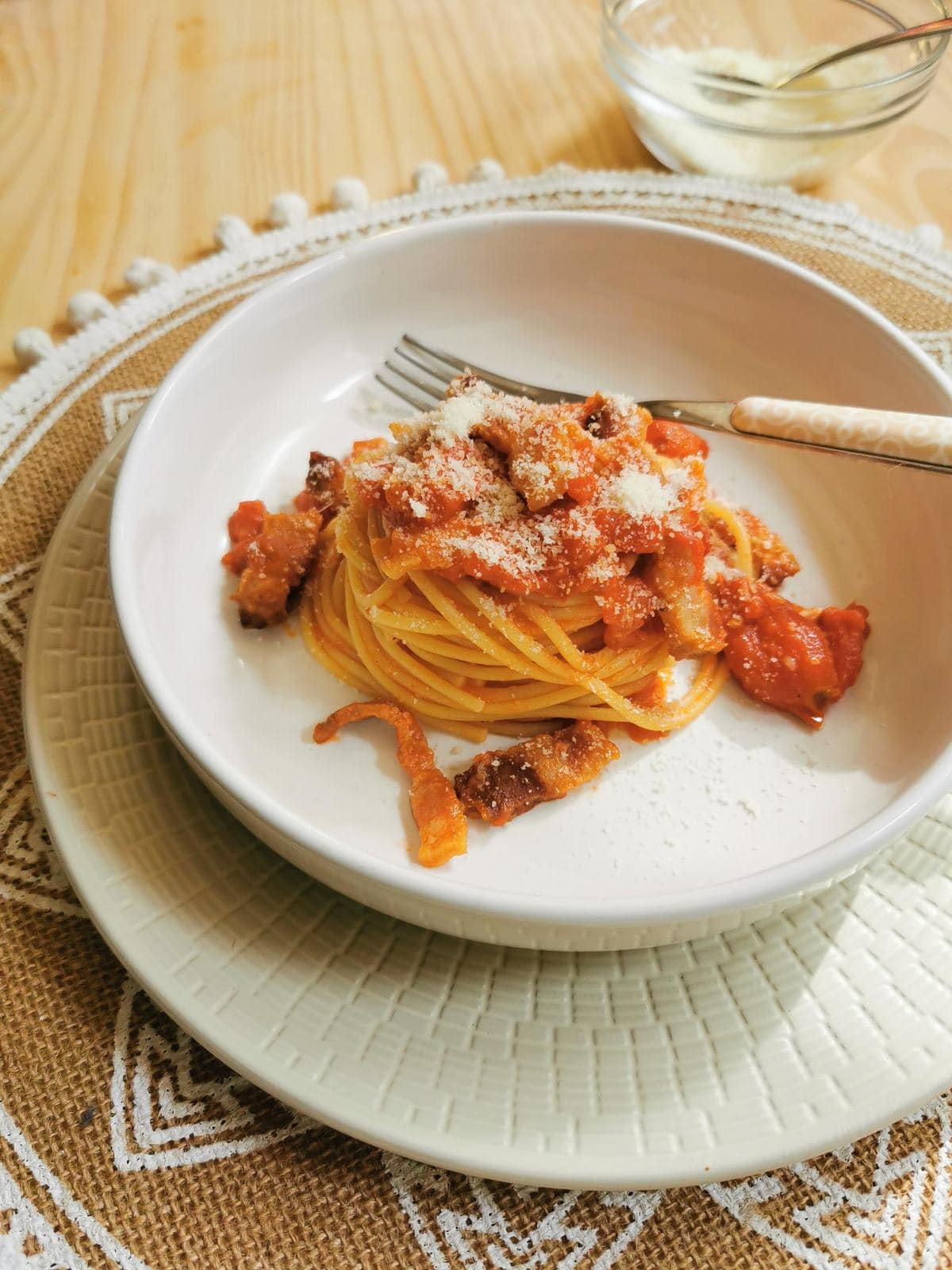 Pasta Amatriciana garnished with Pecorino cheese.