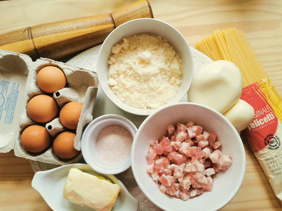 Ingredients for spaghetti frittata on a wood work surface.