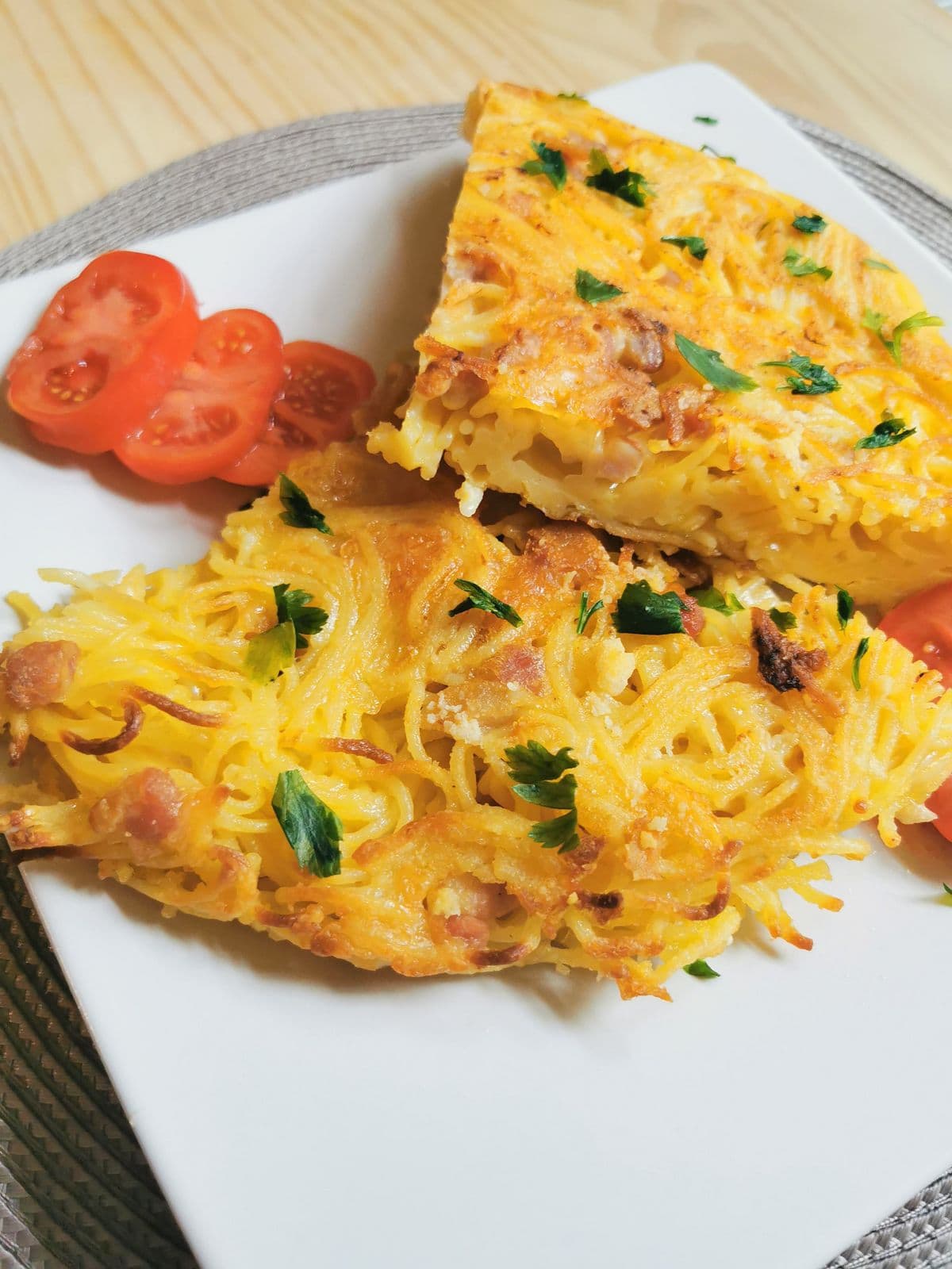 Spaghetti frittata slices on white plate.