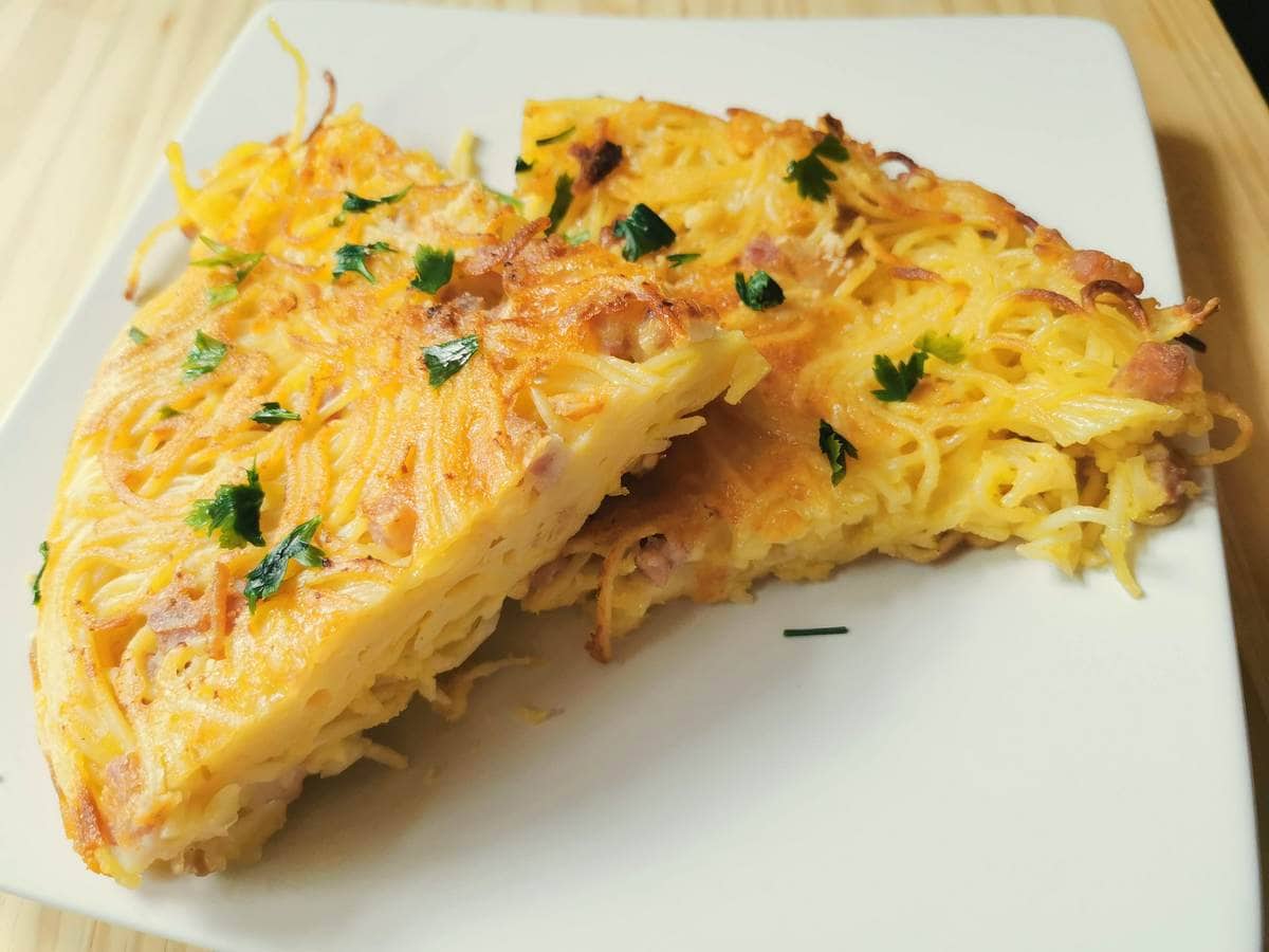 slices of Neapolitan spaghetti frittata on white plate.