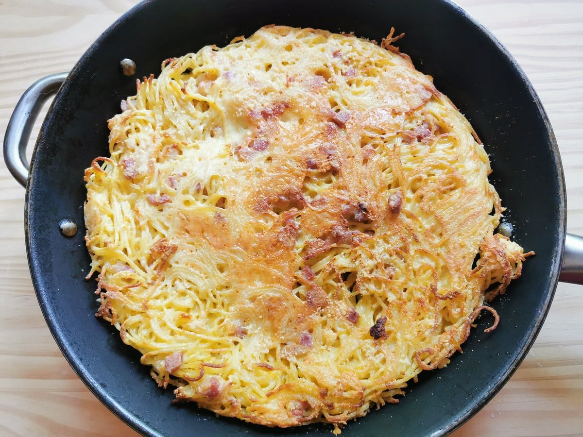 Ready leftover spaghetti frittata in skillet.