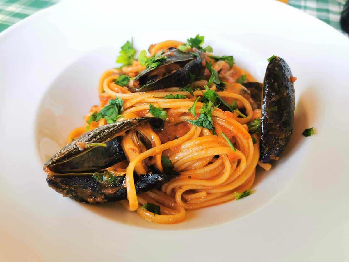 Mussels alla tarantina in a white bowl.