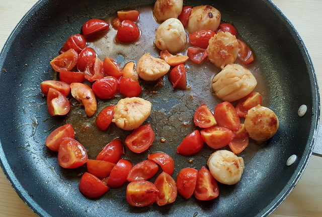 scallops and cherry tomatoes cooking in frying pan