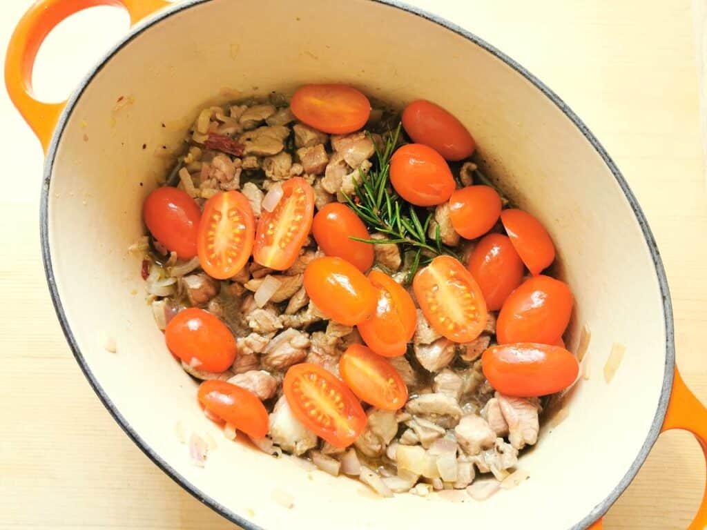 halved cherry tomatoes added to the Dutch oven