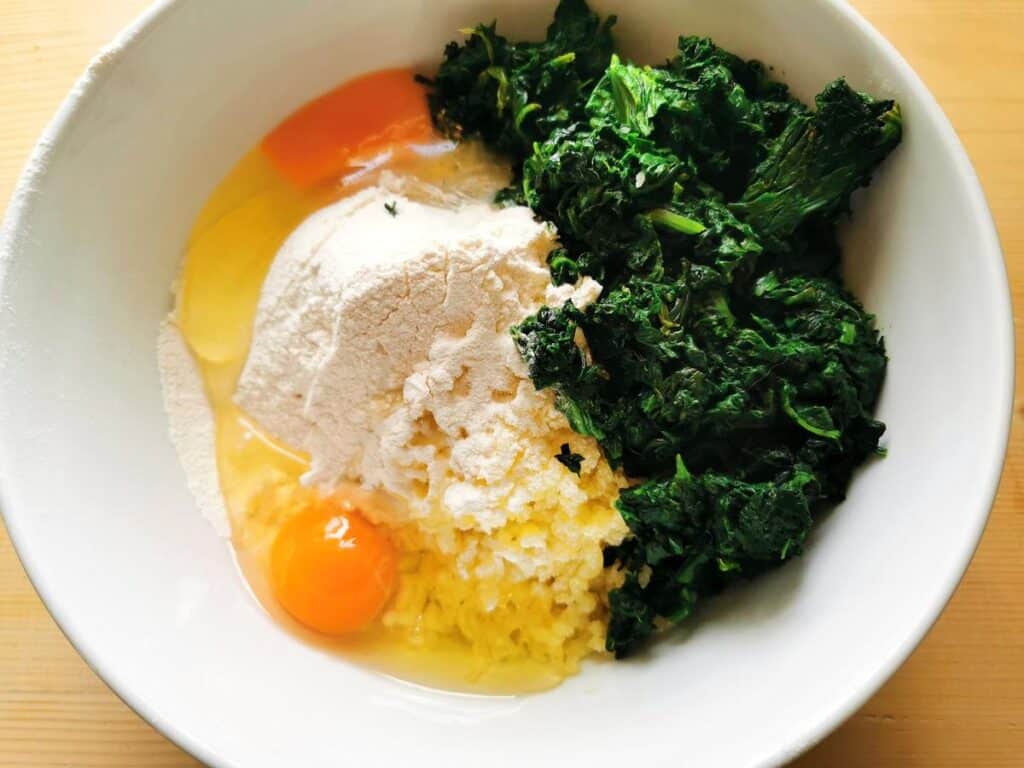 ingredients for spinach and potato gnocchi in white bowl