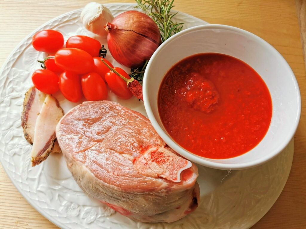 ingredients for lamb ragu on white plate.