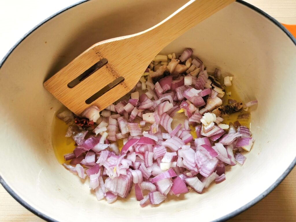 onions, lardo, garlic and peperocino cooking in olive oil in Dutch oven.