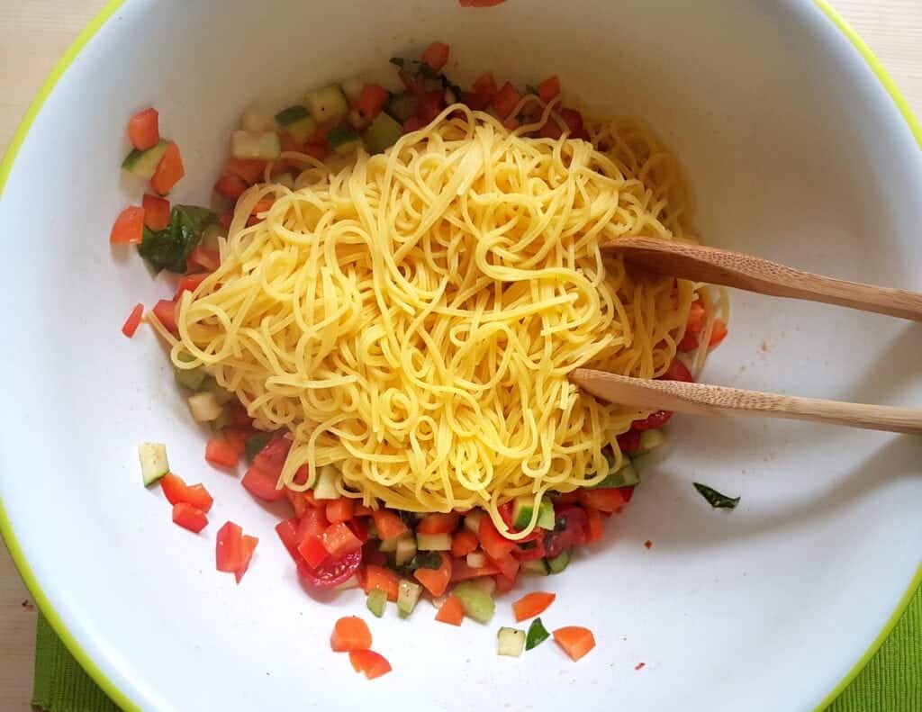 cooked tagliolini in bowl with marinated vegetables