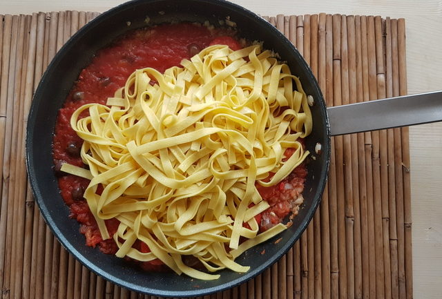 tagliatelle with Mediterranean sauce in frying pan for pasta muffin nests 