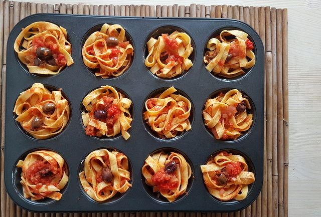 tagliatelle pasta muffin nests in muffin tin before cooking