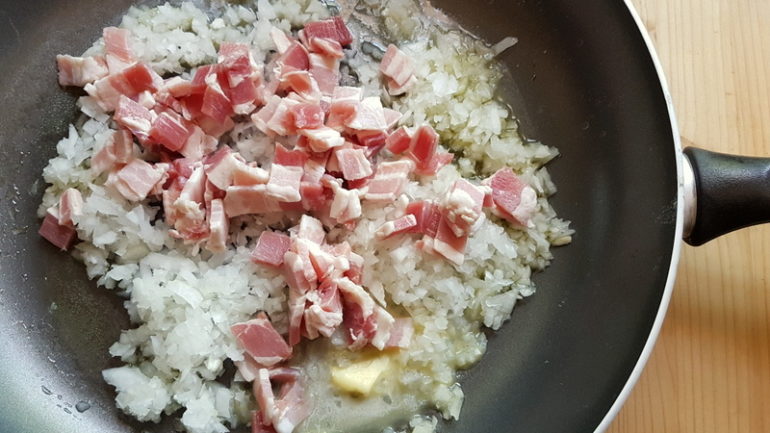 onions and pancetta cooking in frying pan