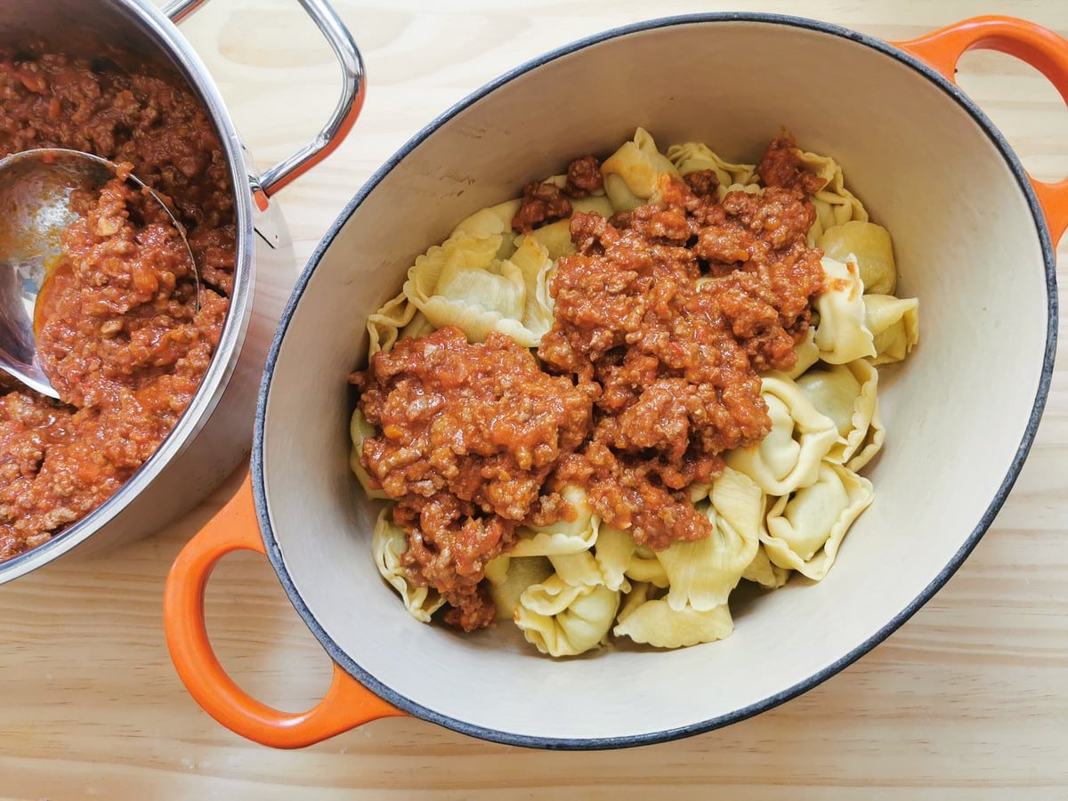 cooked tortellini and some Bolognese sauce in Dutch oven