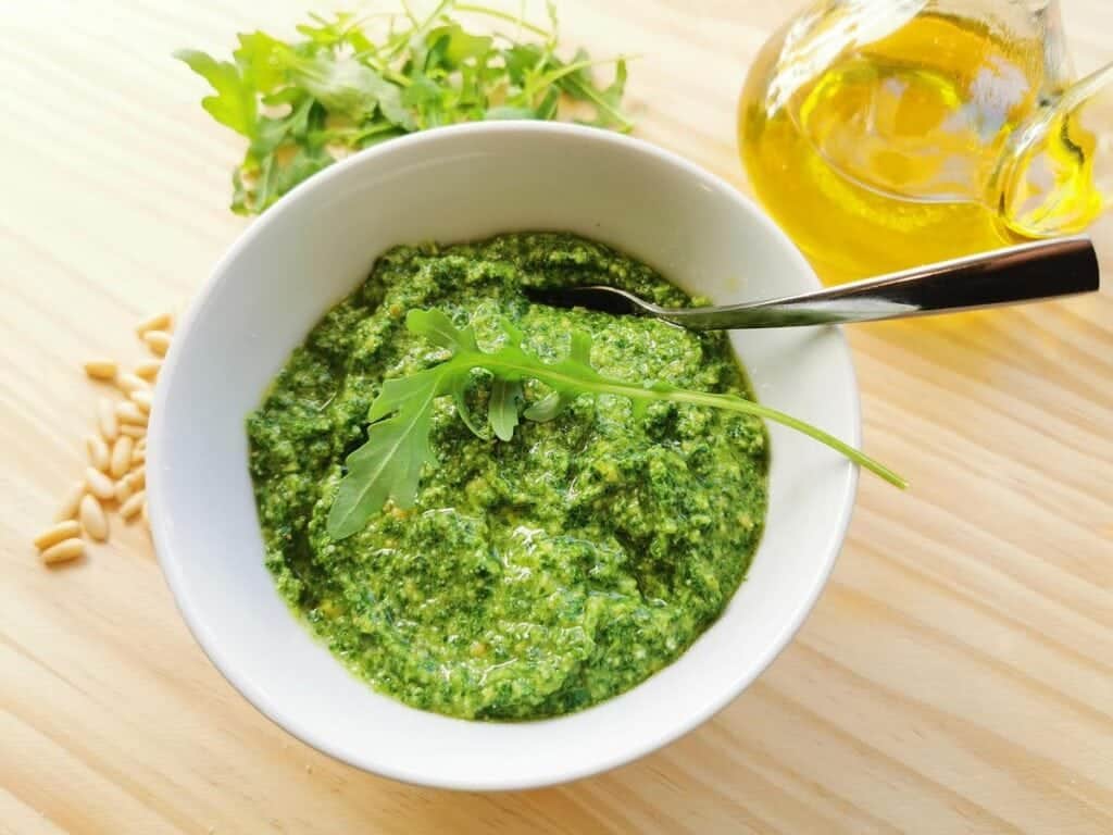 bowl of rocket pesto on wooden board