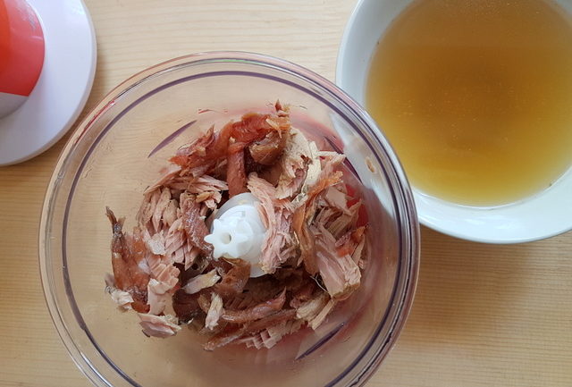 tuna and anchovies in blender next to bowl of beef broth