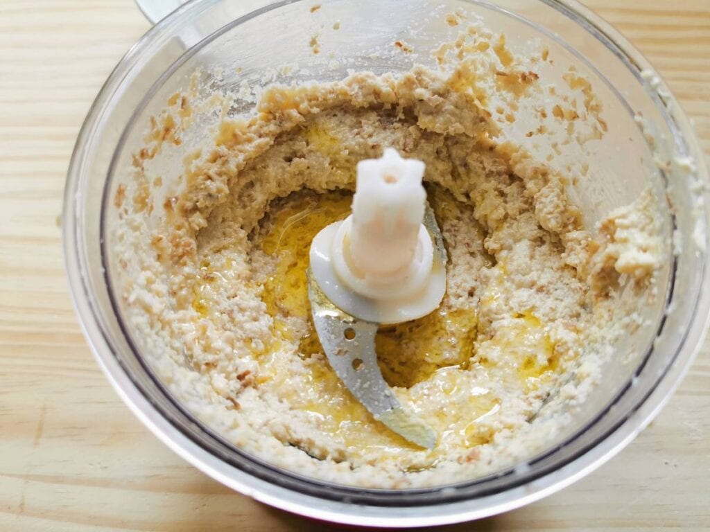 Olive oil added to sauce in food processor.
