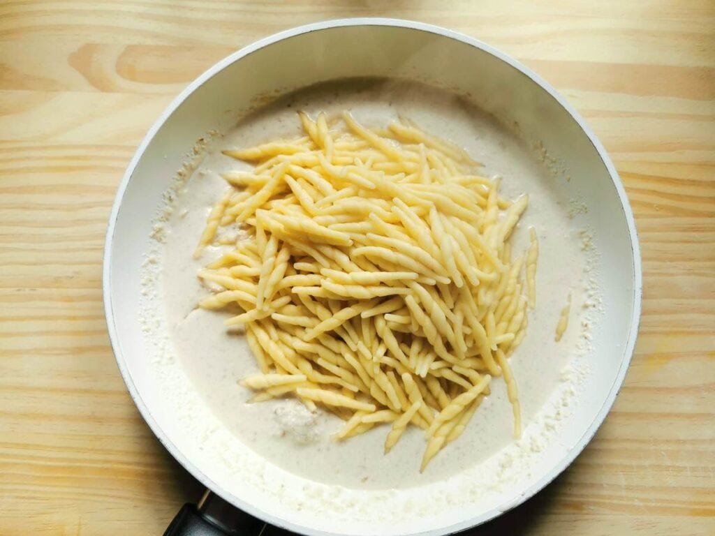 cooked pasta with sauce in pan